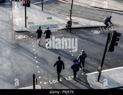 Londra, Inghilterra - 18 Gennaio 2018: un gruppo di persone che camminano per la strada della city di Londra nelle prime ore del mattino Foto Stock