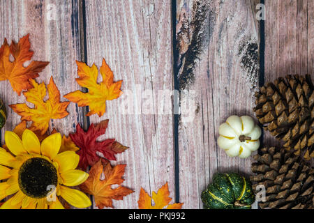 Autunno sfondo con semi di girasole, di foglie, zucche e pigne nelle quali su uno sfondo di legno Foto Stock