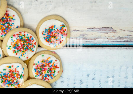 Carino delizioso zucchero vanigliato cookie disposti su un blu sullo sfondo di legno. Spruzza sulla vaniglia cookies smerigliato Foto Stock