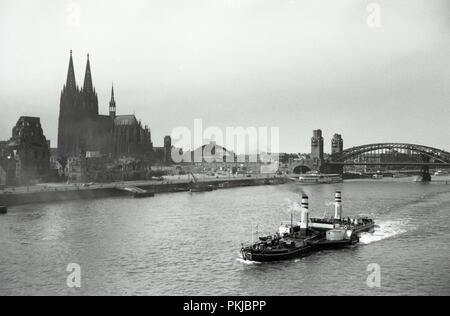 Degli anni Cinquanta, storico, vista su tutta la città vecchia di Colonia, Germania, accanto al fiume Reno, che mostra le aree distrutta dai bombardamenti alleati durante il WW2 e la città famosa cattedrale gotica, che benchè danneggiata non è stata distrutta. Foto Stock