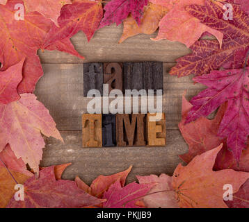 Tempo di caduta del blocco di legno lettering con autunno maple leaf confine su sfondo di legno Foto Stock