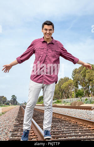 Giovane uomo bilanciamento sulla ferrovia, traclks Calsbad, California Foto Stock