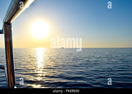 Vista dal yacht sopra l'oceano, horizon in background, cielo blu, tramonto Foto Stock