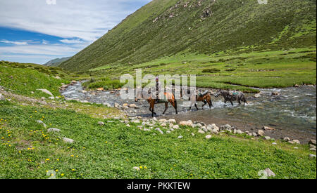 Cavaliere e cavallo trasversale ferroviaria Tup River, Loop Keskenkyia trek, Jyrgalan, Kirghizistan Foto Stock