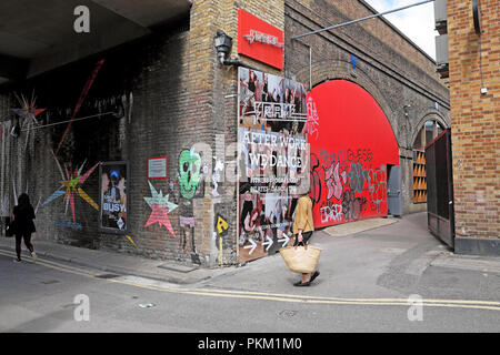 Giovane donna oltrepassando un annuncio per frame di formazione Fitness Studio " dopo il lavoro abbiamo Dance' poster New Inn cantiere, Shoreditch Londra UK KATHY DEWITT Foto Stock