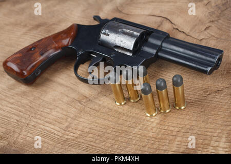 Revolver con munizioni sullo sfondo di legno Foto Stock