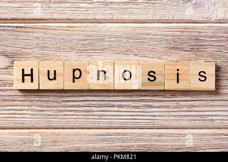 Ipnosi parola scritta sul blocco di legno. Testo di ipnosi su tavola, concetto. Foto Stock