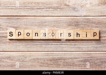 Sponsorizzazione parola scritta sul blocco di legno. La sponsorizzazione del testo in tabella, concetto. Foto Stock