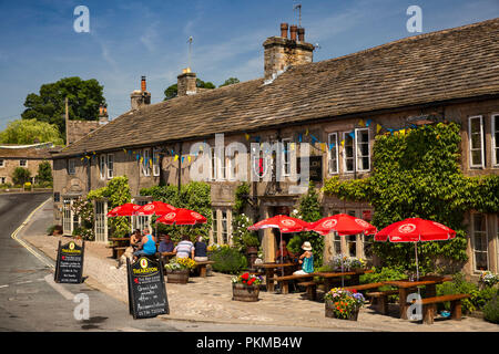 Regno Unito, Yorkshire, Wharfedale, Burnsall, Red Lion e Manor House hotel i clienti al di fuori nella luce del sole Foto Stock