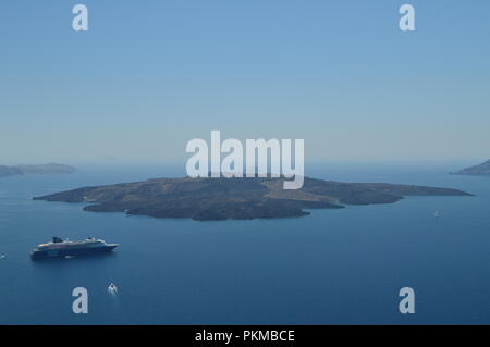 Viste della baia di Thera da Fira con una crociera ormeggiata su di esso e la splendida vista dell'isola che siede di fronte a. Architettura, paesaggi, viaggi Foto Stock