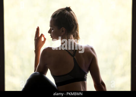 Giovane donna sportiva in Ardha Matsyendrasana pongono, close up Foto Stock