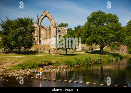 Regno Unito, Yorkshire, Wharfedale, Bolton Abbey, pietre miliari su fiume Wharfe sotto convento agostiniano rovine Foto Stock