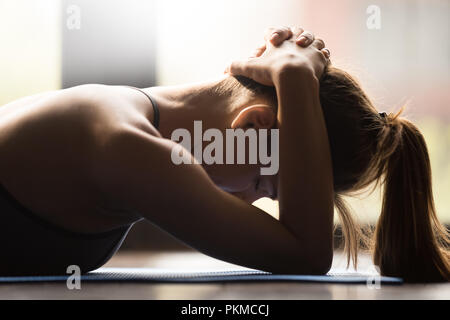 Giovane donna facendo il muscolo del collo esercizio di gruppo Foto Stock