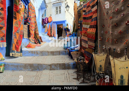 Tipici tappeti fatti a mano esposte per la vendita su una strada a Chefchaouen, Marocco Foto Stock