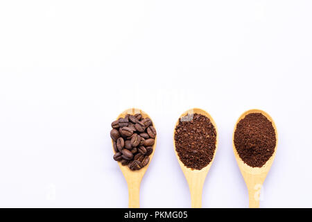 Cucchiai di legno riempito di caffè in grani frantumati e caffè macinato su sfondo bianco Foto Stock