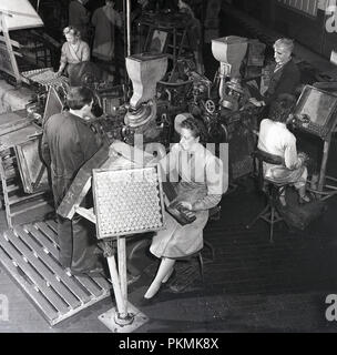 Degli anni Cinquanta, storico, di sesso maschile e lavoratori di sesso femminile sul piano della fabbrica del sempre pronto battery company, Walthamstow, Londra, Inghilterra. Foto Stock