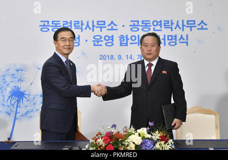 Settembre 14, 2018 - Seoul, Corea del Sud - Sep 14, 2018-Kaesong, Nord Corea Korea-South unificazione del Ministro Myoung Cho-gyon, sinistra stringe la mano con Ri figlio Gwon, presidente del Nord del Comitato per la riunificazione pacifica, a destra dopo la firma del documento nel corso di una cerimonia di apertura per due Coree' primo ufficio di collegamento a Kaesong, Corea del Nord, venerdì 7 settembre 14, 2018.(Immagine di credito: © Ryu Seung-Il/ZU Foto Stock