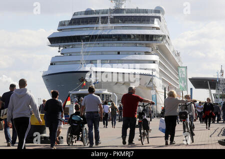 14 settembre 2018, Meclemburgo-Pomerania, Rostock: i passanti sul loro modo al passeggero il molo dove la nave da crociera Marina di Oceania Cruises può essere visto in background. Warnemuende ospita la prima crociera di Rostock Festival. Il nuovo festival marittimo della città anseatica, tra il 14 e 16 settembre, si intende informare i visitatori circa crociere, tra le altre cose, e allo stesso tempo circa il rendimento della costruzione navale nel Meclemburgopomerania Occidentale. Foto: Bernd Wüstneck/dpa Foto Stock