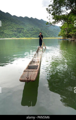 Una donna della minoranza etnica Tay nel suo costume tradizionale è il canottaggio una piroga su Ba essere Lago. Ba essere Lago è una famosa località turistica in Bac Kan, VN Foto Stock