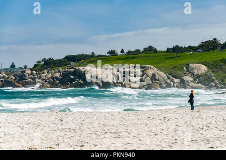 Lone donna su una spiaggia affacciata sul mare, a sud dell'Oceano Atlantico, Camps Bay, Sud Africa Foto Stock