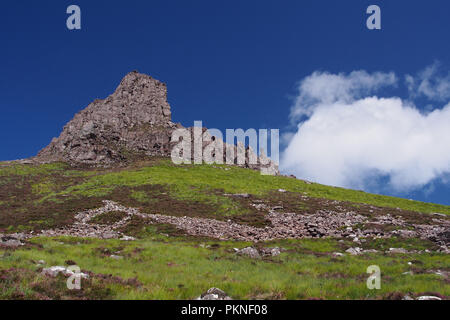 Una vista guardando fino al west end di Stac Pollaidh montagna da halway giù il percorso bagna con adeep cielo blu e nuvole bianche Foto Stock