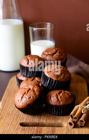 Fatti in casa muffin al cioccolato (brownies) con cannella e latte sulla carta marrone sfondo Foto Stock