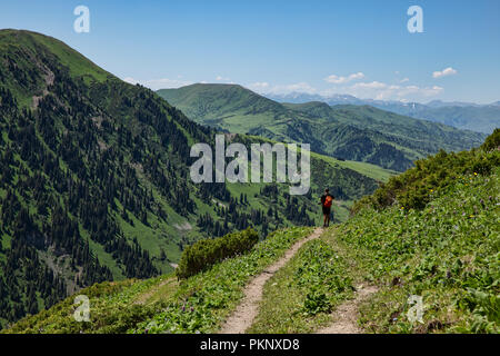 Trekker scende al fiume Tyup valley, Loop Keskenkyia trek, Jyrgalan, Kirghizistan Foto Stock