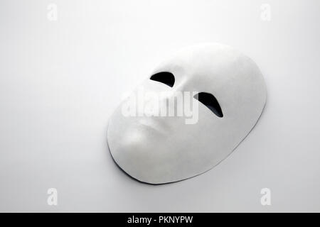 Maschera bianca su sfondo bianco con ombra Foto Stock