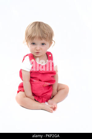 Carino dagli occhi blu bambina facendo una faccia buffa. Foto Stock