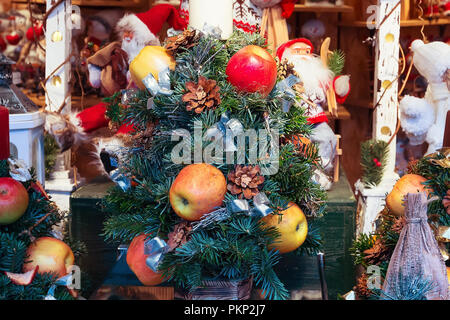 Mercatino di Natale in stallo con albero di natale, mele, pigne e doni per la vendita Foto Stock