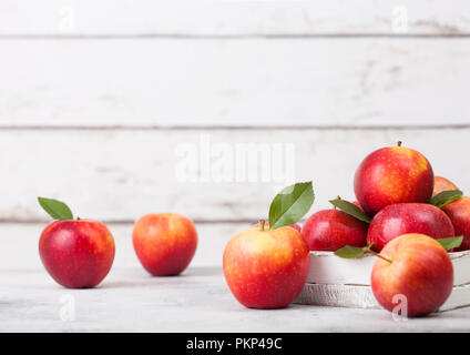 La Braeburn Pink Lady mele nella scatola di legno bianco su uno sfondo di legno Foto Stock