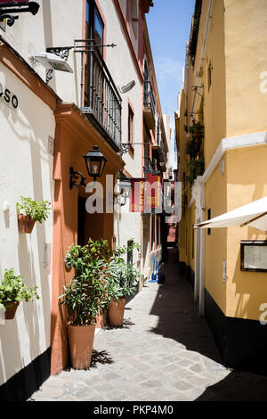 Siviglia, Spagna, 18 Giugno 2017: stretto vicolo nel mezzo di edifici di Siviglia Foto Stock