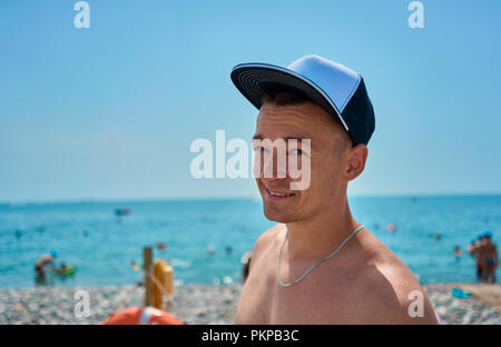 L'uomo nel cappuccio sulla spiaggia Foto Stock