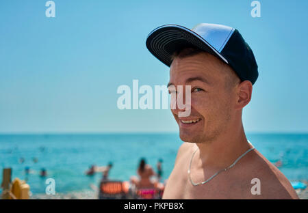 L'uomo nel cappuccio sulla spiaggia Foto Stock