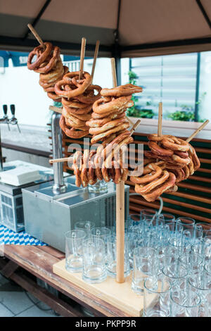 Fresca pretzel tedesco su un rack di legno per la birra Foto Stock