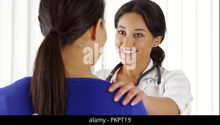 African American paziente parla al medico di origine ispanica Foto Stock