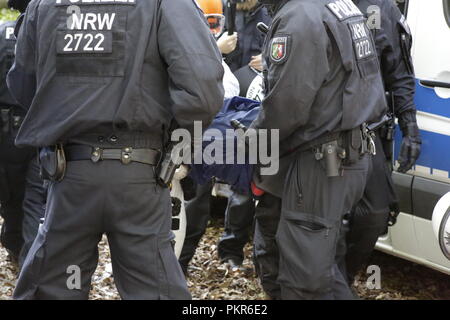 Kerpen, Germania. Xiv Sep, 2018. Sommossa degli ufficiali di polizia cerca uno degli attivisti detenuti. Il giorno 2 di lo sfratto di attivisti provenienti dalla zona occupata Hambach foresta dalla polizia hanno visto un ulteriore albero case distrutte e gli attivisti detenuti nonché una seconda marcia di protesta dei sostenitori. La foresta di Hambach è supposto per essere cancellato per fare spazio per l'estensione della vicina miniera di lignite da tedesco electric utilities azienda RWE e è stato occupato da attivisti ambientali per diversi anni, che vivono in case ad albero. Credito: Michael Debets/Pacific Press/Alamy Live News Foto Stock