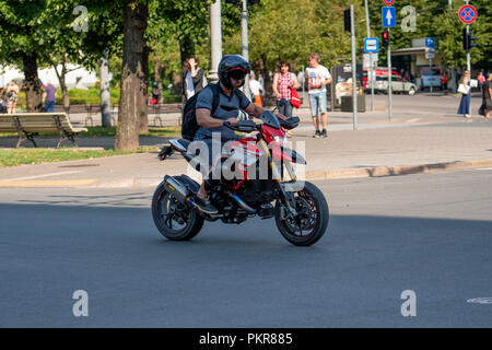 RIGA, Lettonia - 18 luglio 2018: un uomo alla guida di una motocicletta attraverso il centro della città street. Foto Stock