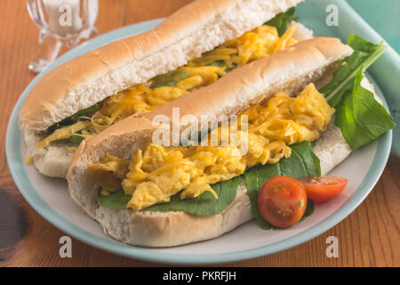 Uova strapazzate panino - due rotoli di pane con uova strapazzate e rucola close up su piastra Foto Stock