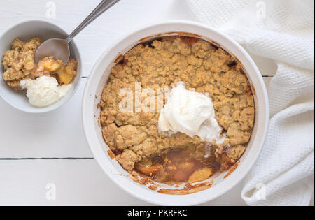 Apple Crumble dessert con gelato alla vaniglia su sfondo bianco - vista superiore foto Foto Stock