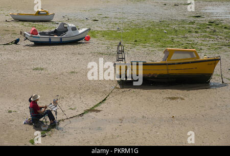 Artista seduto sulla sabbia quando la marea è fuori della pittura, Braccio del porto, Margate, Kent Foto Stock