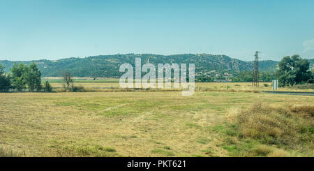 Montagne e l'erba la campagna spagnola di Cordoba, Spagna, Europa, Anadalucia su una luminosa giornata soleggiata con cielo blu Foto Stock