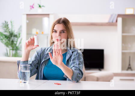 Donna di prendere le pillole per affrontare il dolore Foto Stock