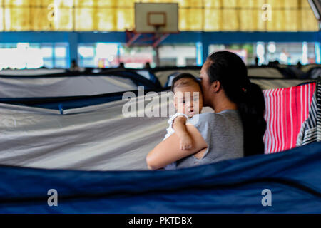 Manila, NCR, Filippine. Xv Sep, 2018. Una madre e il suo bambino in corrispondenza alla zona di evacuazione in Malanday, Marikina City.Il 14 settembre 2018, Super Typhoon Mangkhut ha colpito le Filippine con velocità del vento di 205 chilometri all'ora (km/h), e raffiche di vento arrivano fino a 255 km/h. Più di un migliaio di cittadini filippini in tutto il paese sono state colpite. Credito: ZUMA Press, Inc./Alamy Live News Foto Stock