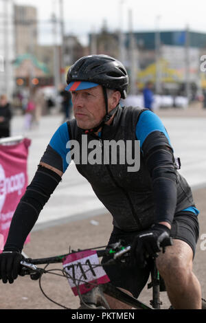 Blackpool, Lancashire, Regno Unito. Il 15 settembre 2018. "Pedale al Molo' Mencap Off road cycling 100km Challenge. Il fango è spruzzato sulle concorrente 711 si avvicina al traguardo dopo una estenuante 60 miglio carità off-road in bicicletta da Manchester a Blackpool, terminanti in corrispondenza del promontorio della torre. Credito; MediaWorldImages/AlamyLiveNewsMencap Off road cycling 100km Challenge. Il fango è spruzzato sulle concorrente si avvicina al traguardo dopo una estenuante 60 miglio carità off-road in bicicletta da Manchester a Blackpool, terminanti in corrispondenza del promontorio della torre. Credito; MediaWorldImages/AlamyLiveNews Foto Stock