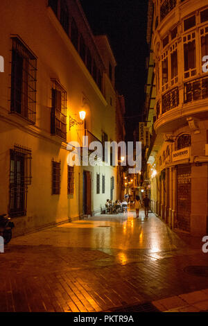 Spagna, Malaga - 24 Giugno 2017: strada illuminata nel mezzo di edifici di notte Foto Stock