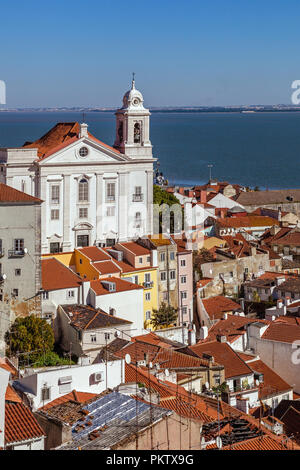 Quartiere di Alfama con Santo Estevao chiesa e il fiume Tago estuario visto da Miradouro de Santa Luzia viewpoint. Lisbona, Portogallo. Foto Stock