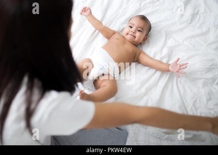 Un asia mather giocando con sua figlia sul letto. Foto Stock