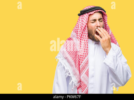Giovane uomo bello indossare keffiyeh su sfondo isolato annoiati sbadigli stanchi che copre la bocca con la mano. Inquieto e sonnolenza. Foto Stock