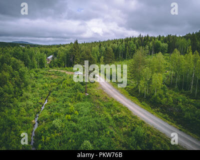 Auto lasciando una casa nella foresta nel nord della Finlandia, visto dal cielo Foto Stock